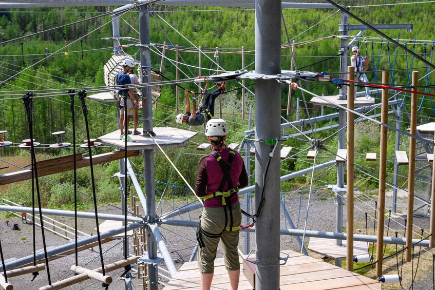 An outdoor adventure course with suspended platforms and ropes. 5