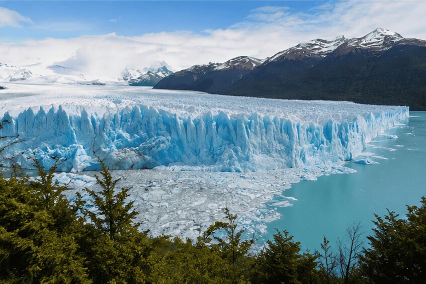 A glacier with a turquoise lake in the foreground and snow-capped mountains in the background. 3