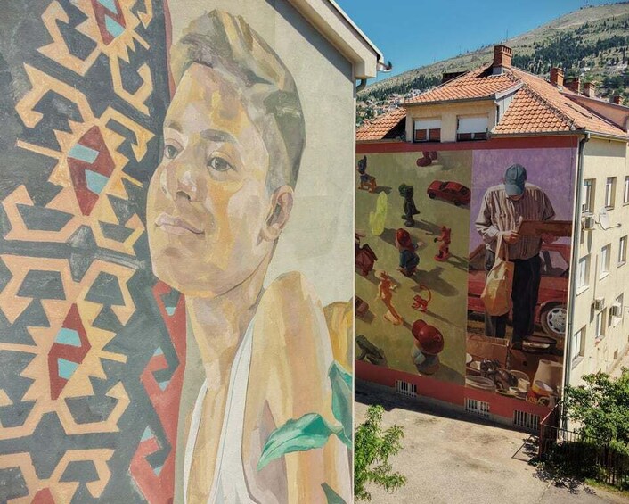A mural with geometric patterns and a figure holding a child. 1
