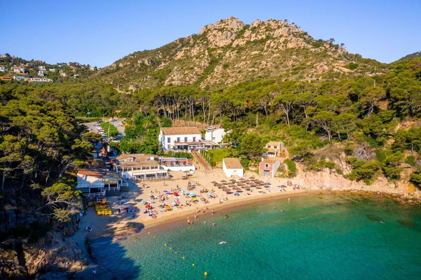 A coastal town with a beach, buildings, and a mountain. 3