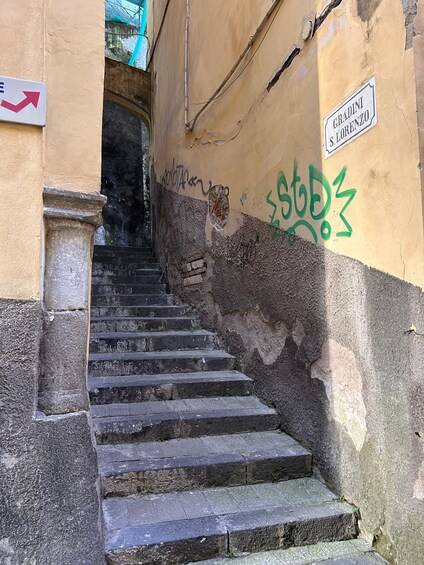 A set of stone steps leading up to a building with a sign reading 'Gradini S. Lorenzo.' 4