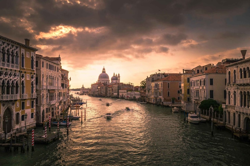 A canal with boats, historic buildings, and a prominent dome structure in Venice. 2