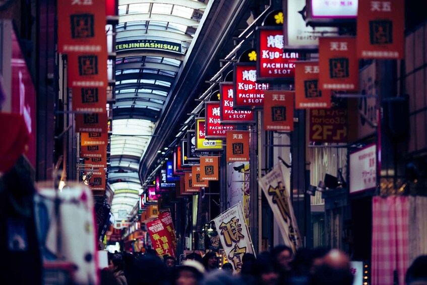 A busy urban street with neon signs and billboards. 1