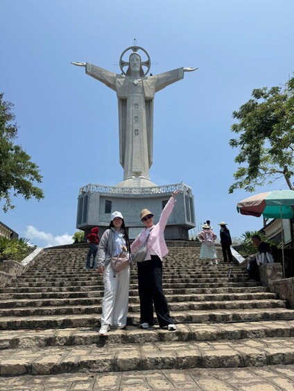 A large statue with outstretched arms on a set of stone steps. 5