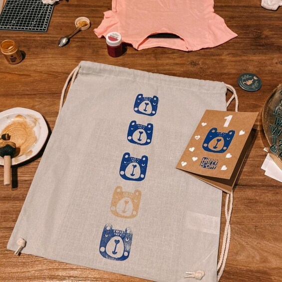 A table with a cloth featuring bear illustrations, a birthday card, and various food items. 5