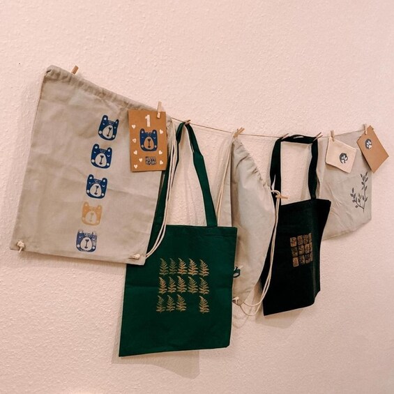 Three bags hanging on a wall with tags. 3
