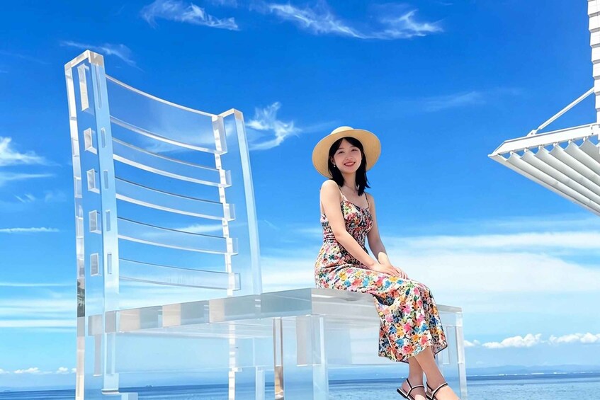 A person sitting on a transparent chair with a clear view of the ocean and sky. 2