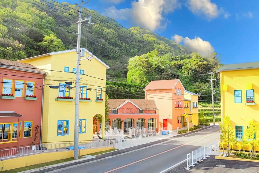 A street lined with colorful buildings, a clear sky, and a hilly backdrop. 3