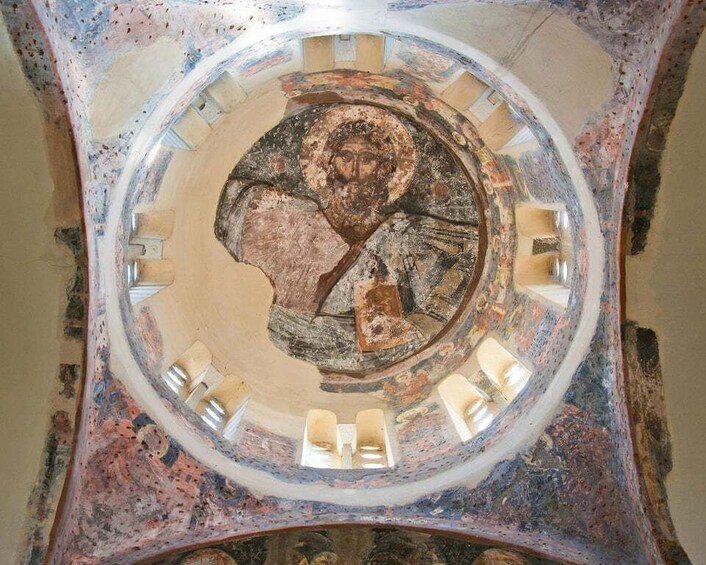 A circular mosaic with a central figure, surrounded by geometric patterns and a ring of smaller figures. 1
