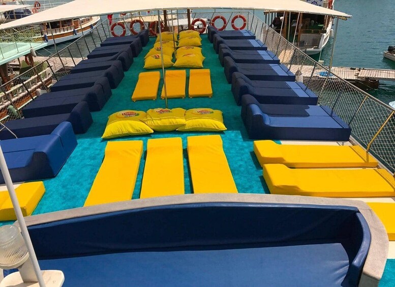 A deck with blue and yellow loungers, life rings, and a clear view of the water. 5
