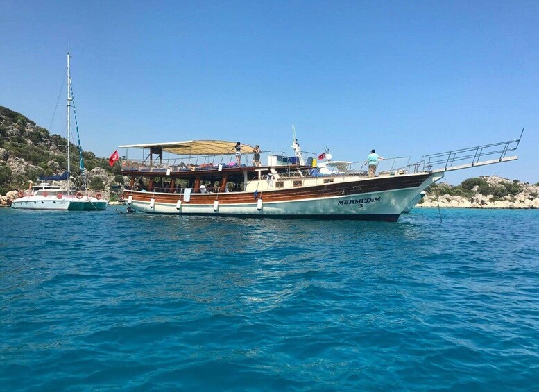 A boat named 'MEHMEDIM' on calm waters with a clear sky. 2