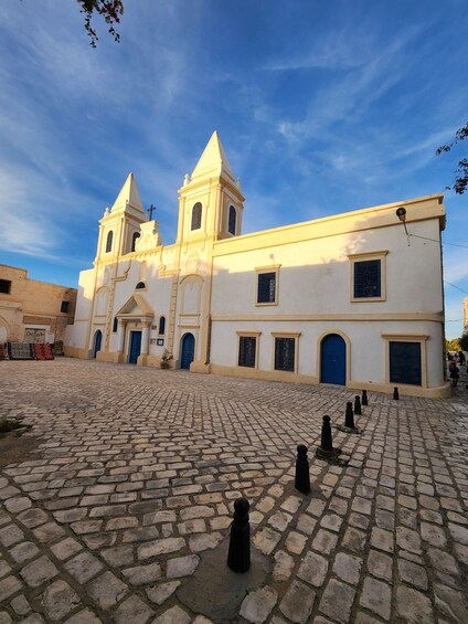 A historic church with two towers and a cobblestone courtyard. 5