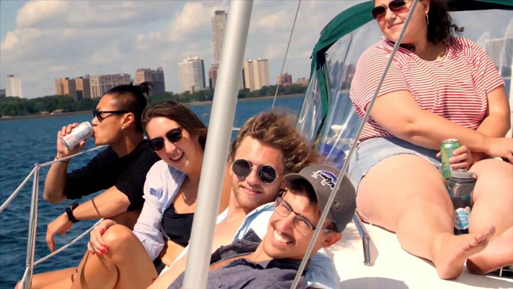 A group of people on a sailboat with a city skyline in the background. 5