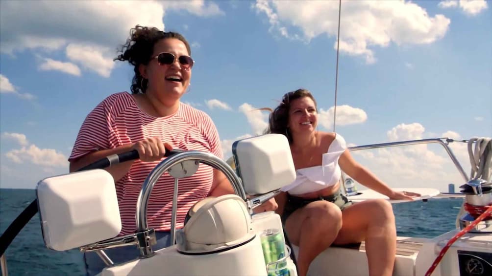 Two people on a boat with a clear sky and water in the background. 4