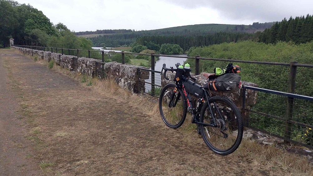 A stone bridge with a bicycle parked on the side. 1
