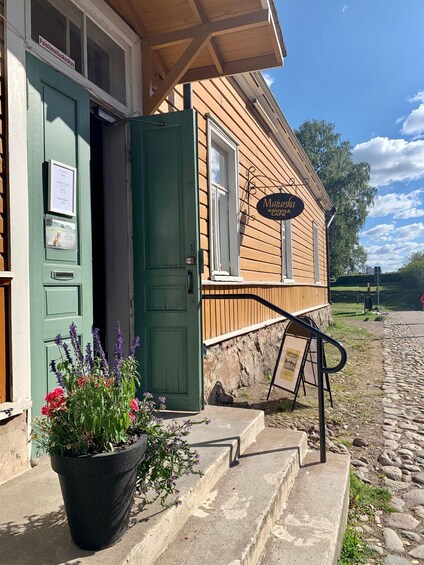 A wooden building with a green door and a sign for 'Majurka Kahvilä Café.' 2