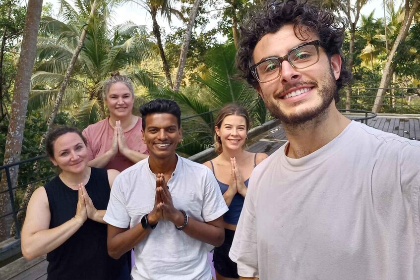 A group of people standing outdoors with palm trees in the background. 5