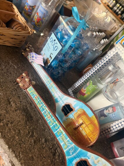 A colorful guitar with a blue and yellow design, a blue plastic bag with a ribbon, and various items on a countertop. 4