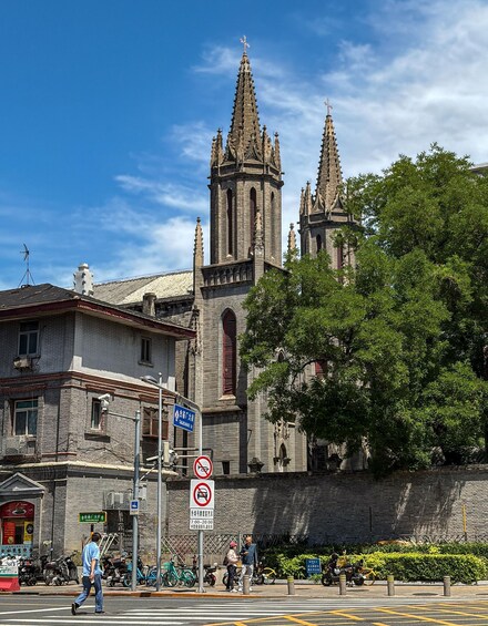 A historic church with twin spires, a pedestrian crossing, and a no parking sign. 3