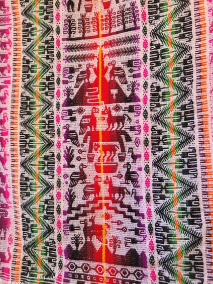 A textile with intricate patterns and a central red motif. 3