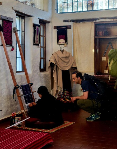 A person weaving on a loom, another person sitting on the floor, and a ladder leaning against the wall. 5