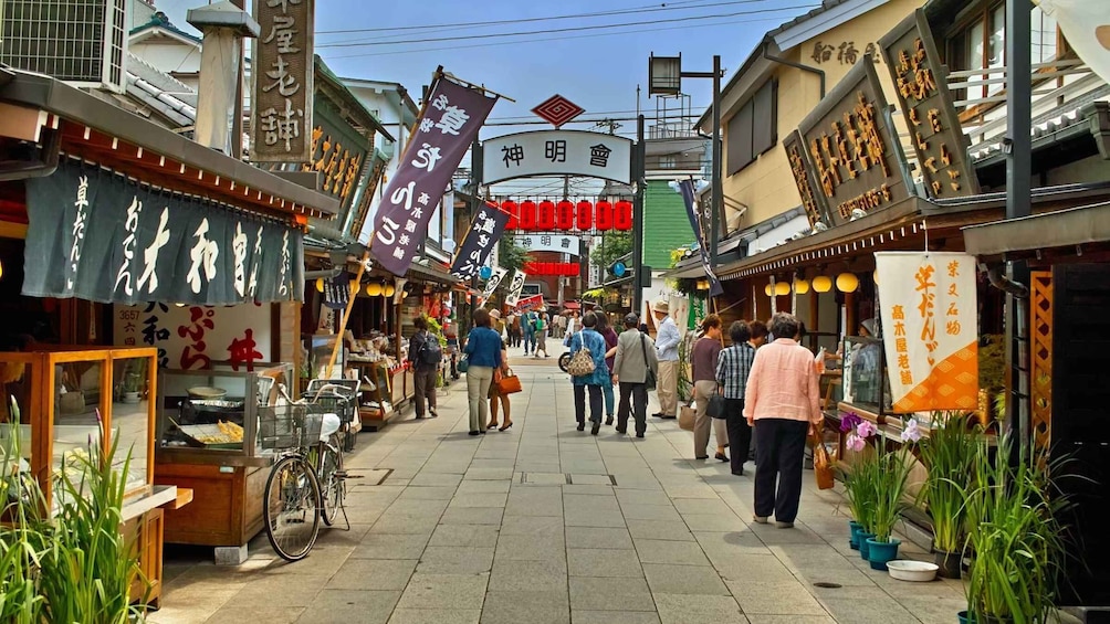 A bustling street market with various shops and signs in a foreign language. 1