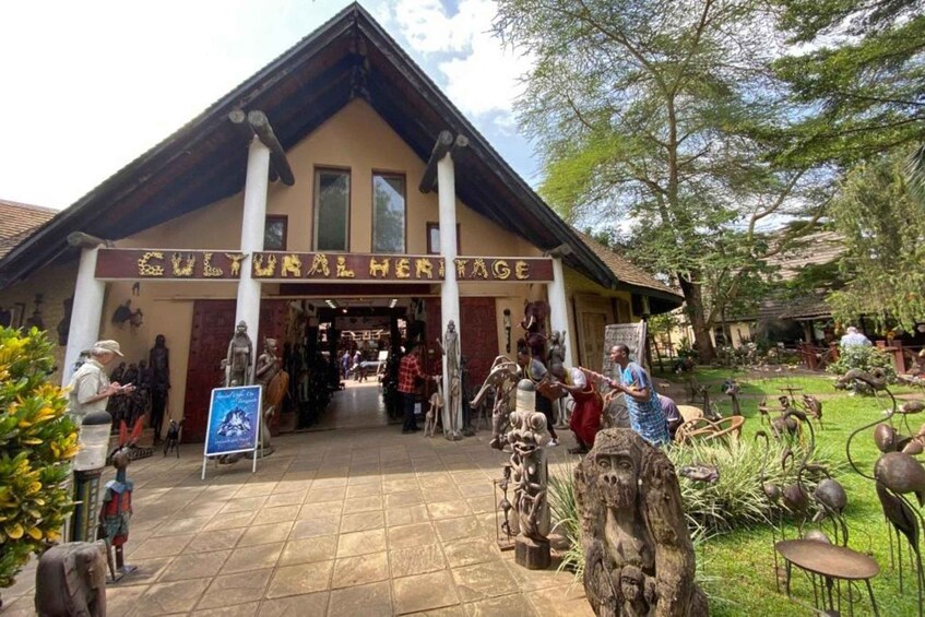 A Cultural Heritage building with a sign, surrounded by sculptures and greenery. 3