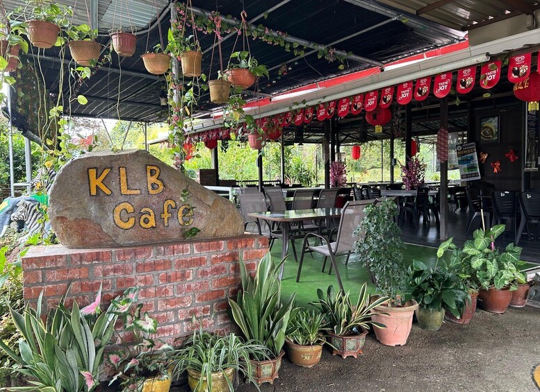 A KLB cafe with outdoor seating, hanging planters, and a brick wall. 3