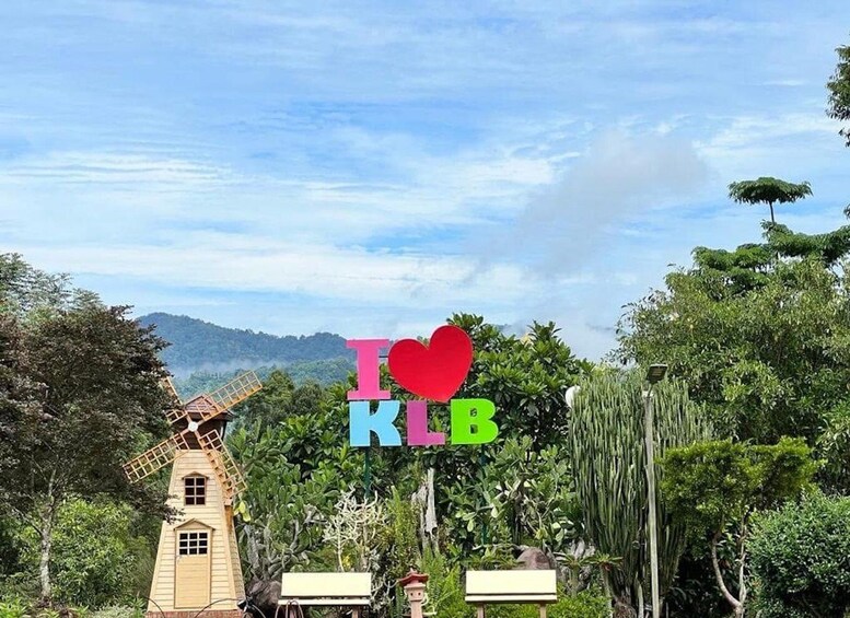 A windmill, lush greenery, and a sign with 'I ♥ KLB' in the background. 2
