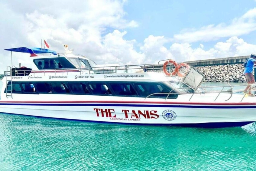 A boat named 'The Tanis' with a lifebuoy and a person standing on the deck. 1