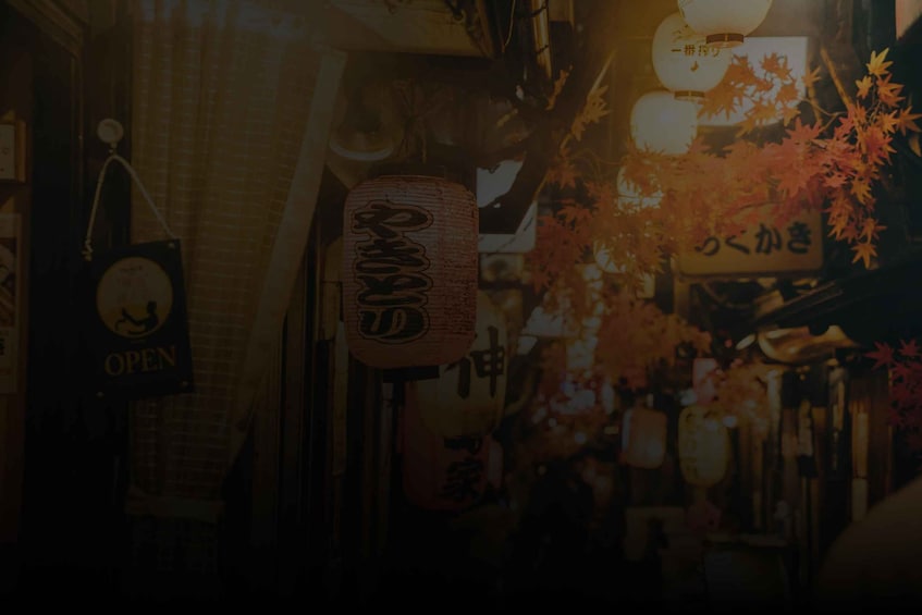 A narrow street with traditional Japanese signage and autumn foliage. 5