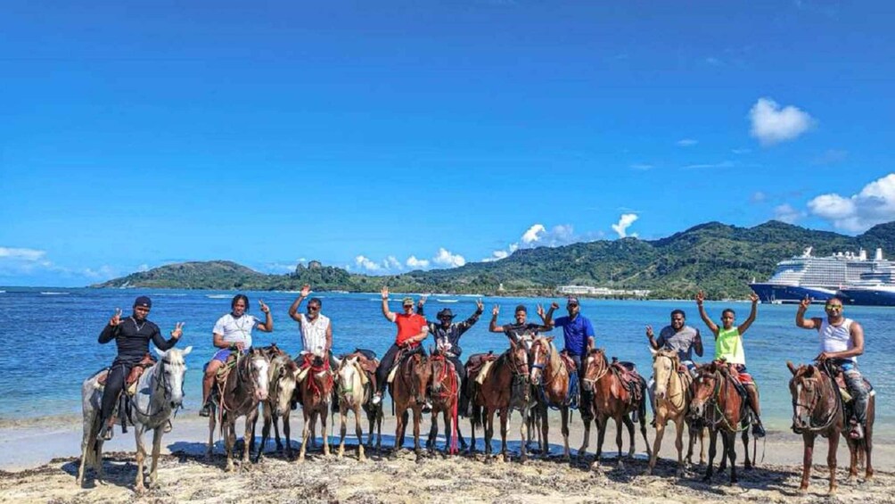 A group of people on horseback by the sea with a cruise ship in the background. 1