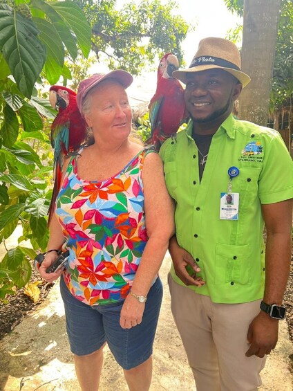 A person in a green shirt with a name tag and a hat, standing next to a woman in a colorful floral top. 3