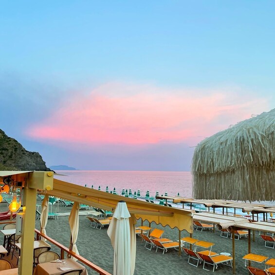 A beachside restaurant with outdoor seating and a view of the sea. 5