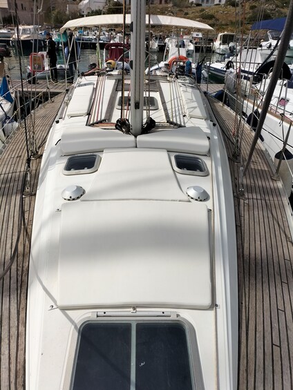 A boat's deck with a white cabin, a steering wheel, and a mast. 4