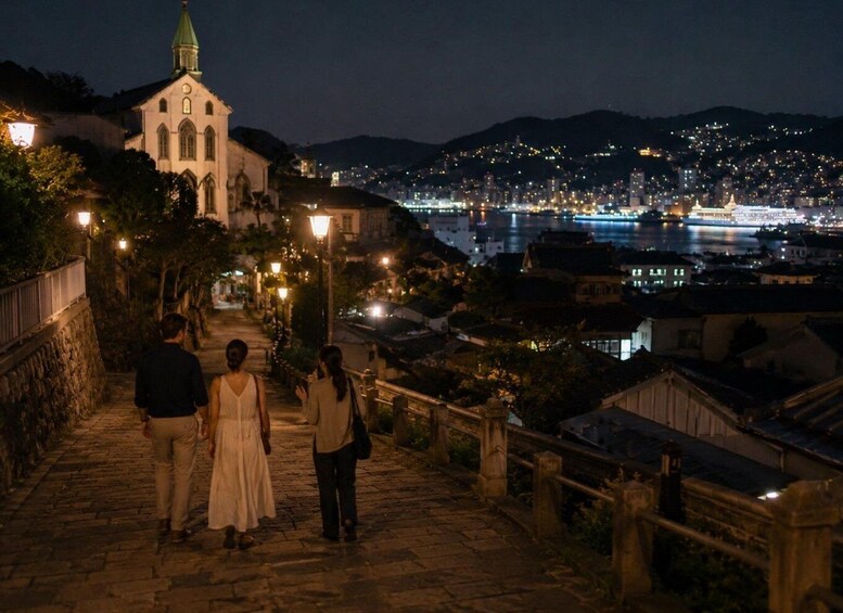 A nighttime cityscape with a church, a river, and a bridge. 2