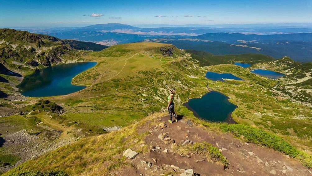 A mountainous landscape with multiple lakes and a person hiking. 4