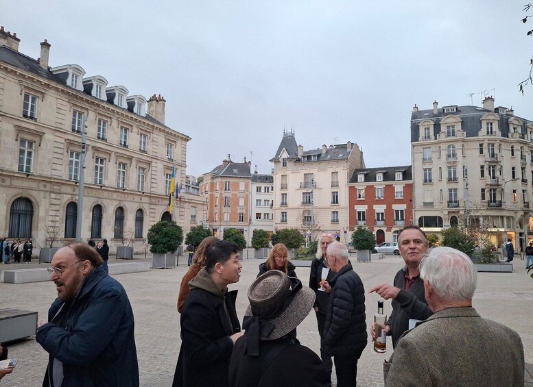 A group of people in a public square with historic buildings in the background. 3