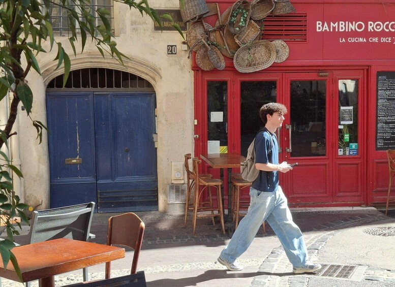 A street scene with a red building, a blue door, and a person walking. 2