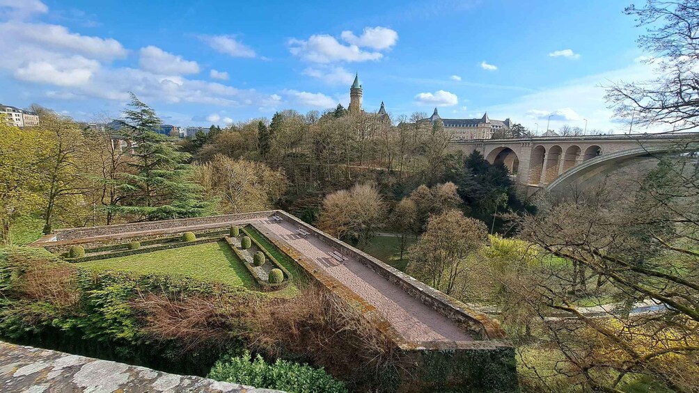 A park with a bridge, a tower, and a historic building. 5