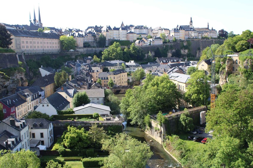 A historic town with a river, buildings, and a castle on a hill. 2
