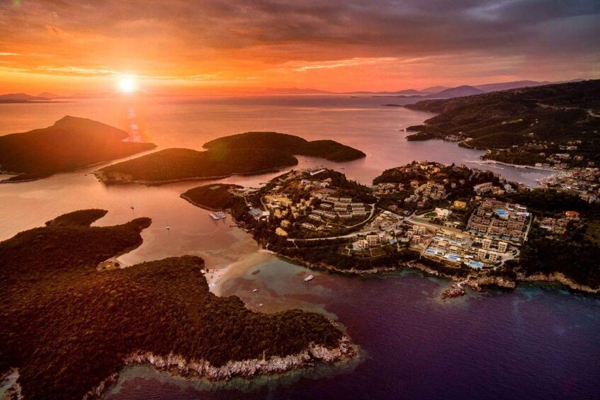 An aerial view of a coastal town at sunset with a clear sky, surrounded by water and islands. 1