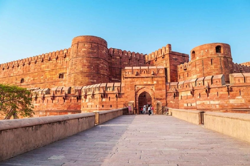 A large, historic fort with a prominent entrance and a long, paved pathway leading to it. 4