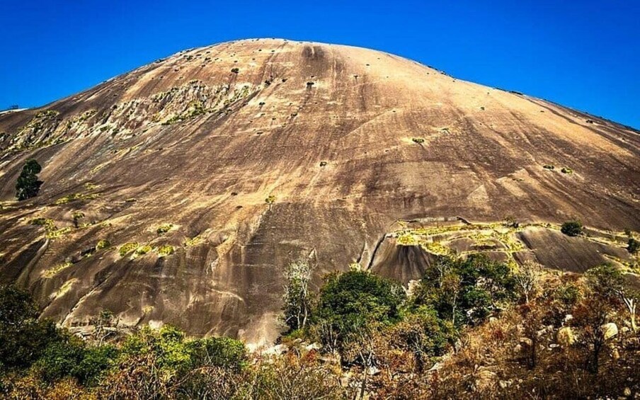 A large, rounded mountain with a clear sky. 2