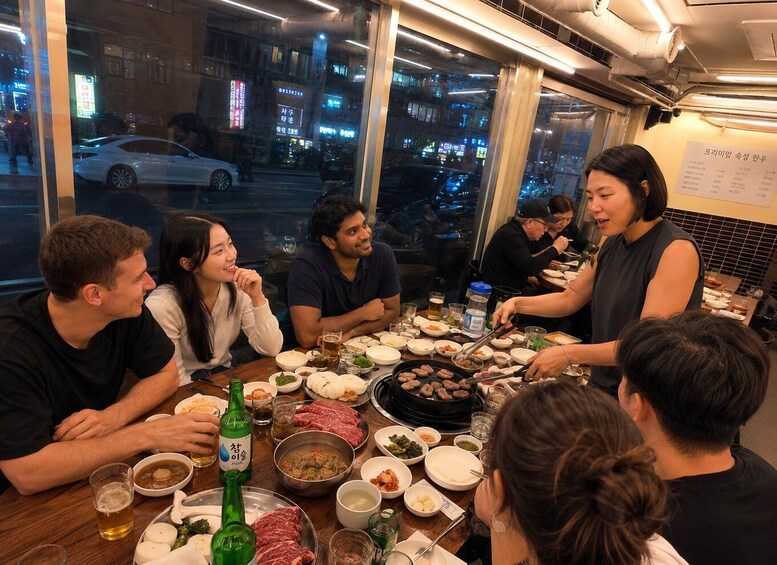A group of people dining at a restaurant with a variety of dishes and drinks on the table. 1