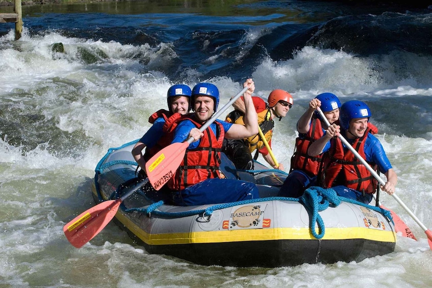 A group of people in a raft navigating a river with rapids. 3