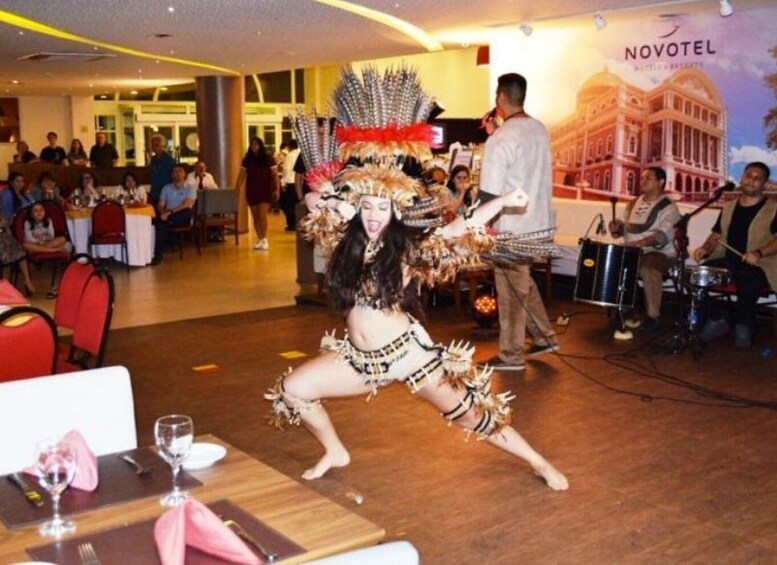 A performer in traditional attire dancing in a hotel lobby. 3