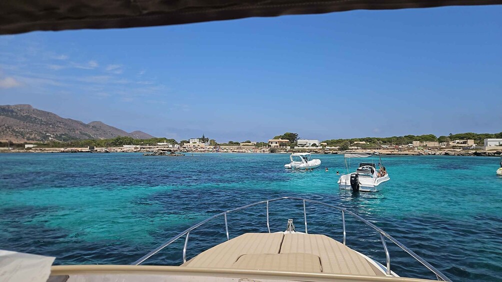 A coastal town with clear turquoise waters, boats, and a mountainous backdrop. 2