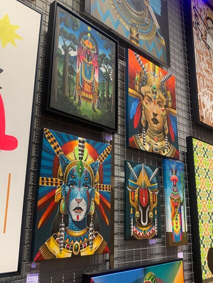 A wall with various colorful paintings, including a depiction of a peacock, a peahen, and a figure with a headdress. 5