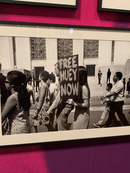 A black and white photo of a protest with a sign reading 'FREE HUEY NOW' in a public square. 2
